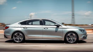 Modern luxury sedan in silver photographed from three-quarter angle on empty highway, premium interior visible through windows, professional automotive photography style
