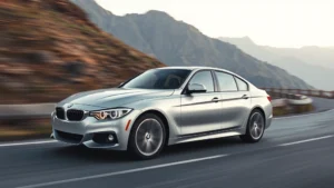 Sleek silver BMW 3 Series sedan driving on winding mountain road, dynamic motion blur, sharp focus on vehicle profile, professional automotive photography