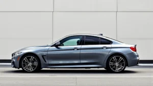 Sleek metallic BMW M440i xDrive luxury sedan in profile view against minimalist urban backdrop, showcasing elegant body lines and modern design