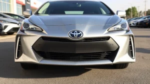 2024 Toyota Prius front three-quarter view, modern aggressive styling, sleek silver finish, professional automotive photography, dealership lot setting, daytime natural lighting, sharp focus on vehicle design details