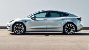 Sleek silver Tesla Model 3 sedan photographed from three-quarter angle in bright daylight, modern minimalist design, aerodynamic profile, professional automotive photography style
