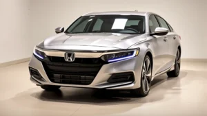 2024 Honda Accord sedan in modern silver, three-quarter front view, clean showroom lighting, emphasis on sleek body lines and LED headlights, professional automotive photography