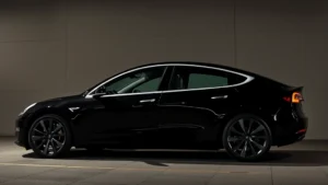 Tesla Model 3 Performance sedan in midnight black, low-angle side profile, modern design, sleek body, dynamic stance, professional automotive photography lighting