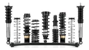 Professional automotive suspension system components including coilover springs, adjustable dampers, and anti-roll bars displayed on white background with metallic finishes