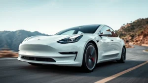 Tesla Model 3 Performance sedan in pearl white multi-coat, three-quarter front view, dynamic driving position on winding mountain road with blurred landscape background, low angle shot emphasizing aerodynamic profile